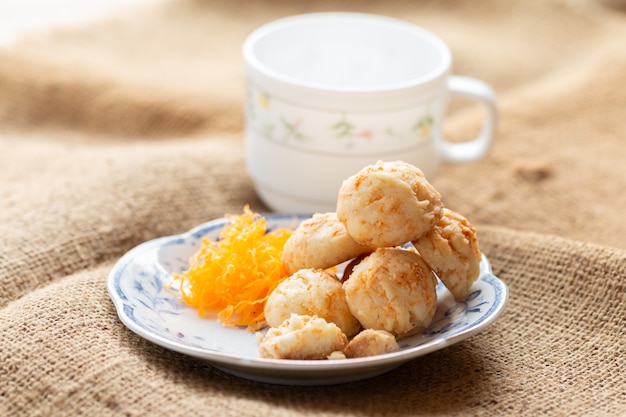 Golden cookies balls with eggs silk for tea time in morning in white plate