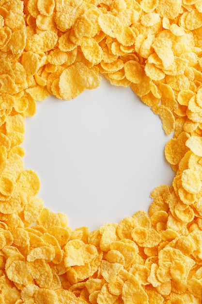 Golden cornflakes on full frame with empty white space. Healthy breakfast