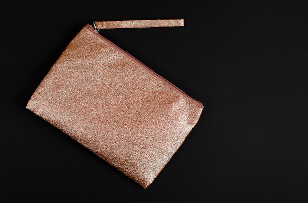 Golden Cosmetic bag on black .