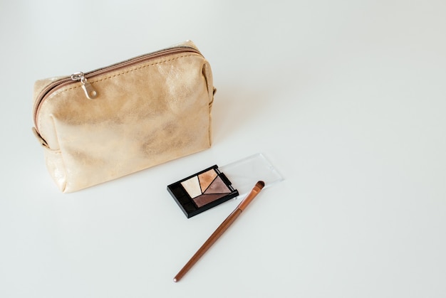 Foto borsa cosmetica dorata con prodotti cosmetici di bellezza
