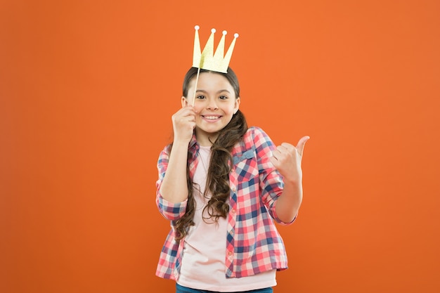 Golden crown suits her. happiness and joy concept. fun and humor. girl child having fun. international childrens day. superior princess. nice day to have fun with photo booth props. playful mood