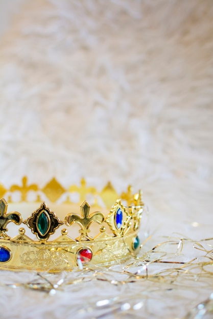 Golden crown with colored gems on a white