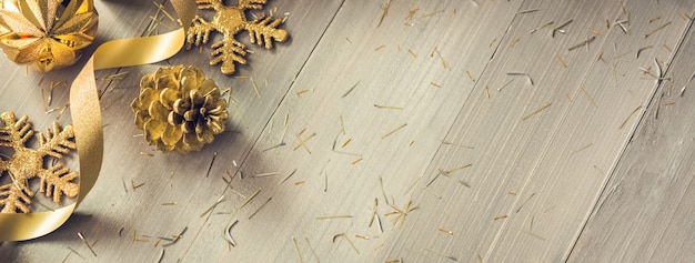 Nastro riccio dorato e luccichio natale decorazione di oggetti su legno banner sfondo