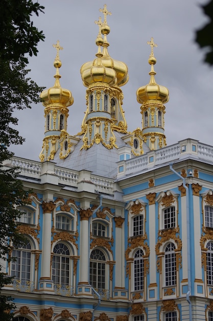 Golden domes of Church and details of facade of emperors palace in Tsarskoe selo museum in Saint Petersburg, Russia