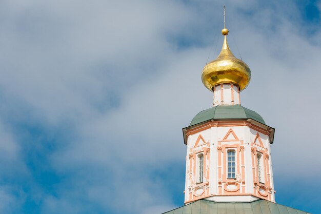 Golden domes of the old ancient temple Picturesque view of the monastery against the blue sky