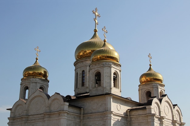 Cupole dorate della chiesa ortodossa contro il cielo blu.