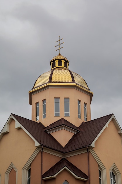 Золотые купола православной церкви с крестом на фоне голубого неба