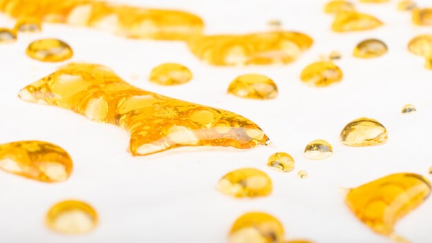 Gocce dorate di concentrato di cannabis, olio di cera con alto contenuto di thc in primo piano