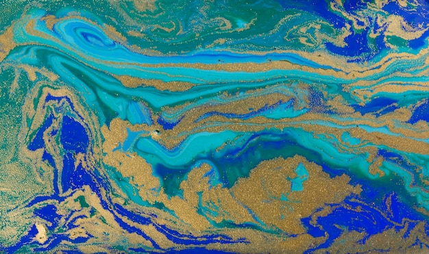 Golden dust on liquid blue ink wave background