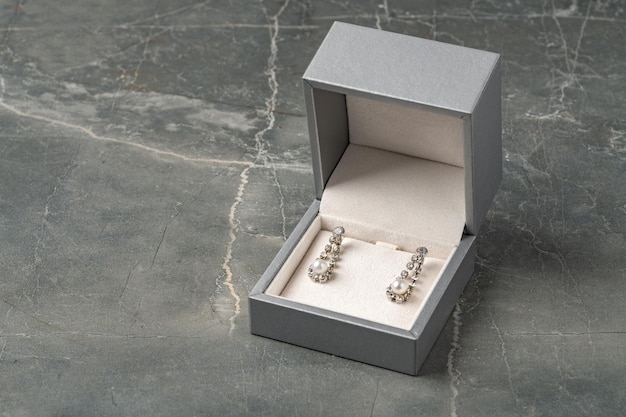 Photo golden earrings and jewelry box on table close up