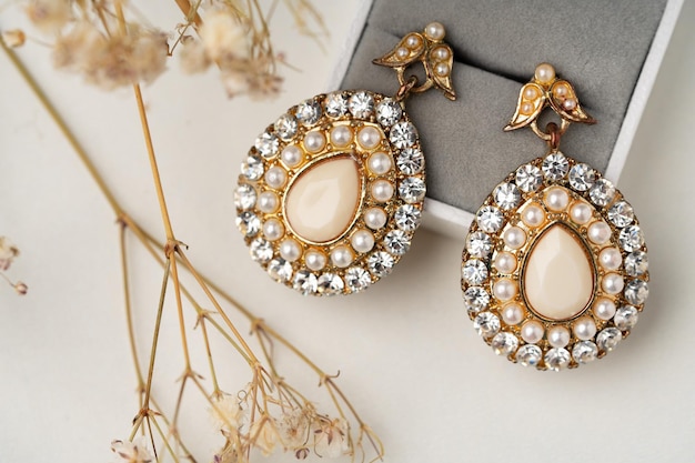 Golden earrings and jewelry box on table close up