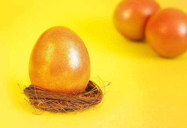 golden easter egg on a stand on a yellow background