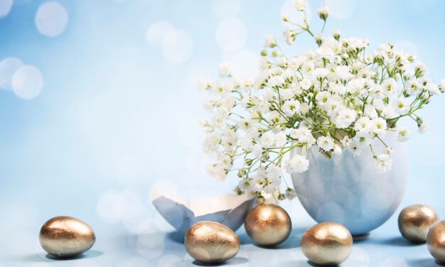 Golden Easter eggs and flowers with bokeh lights