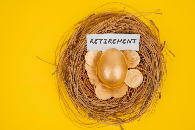 Golden egg and coins with retirement word on nest