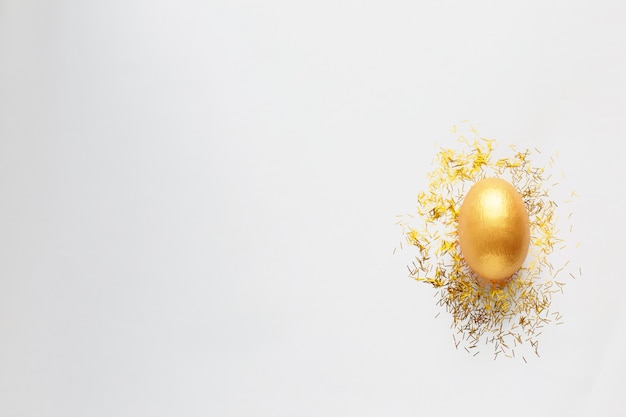 Golden egg and Golden sparkles on white background