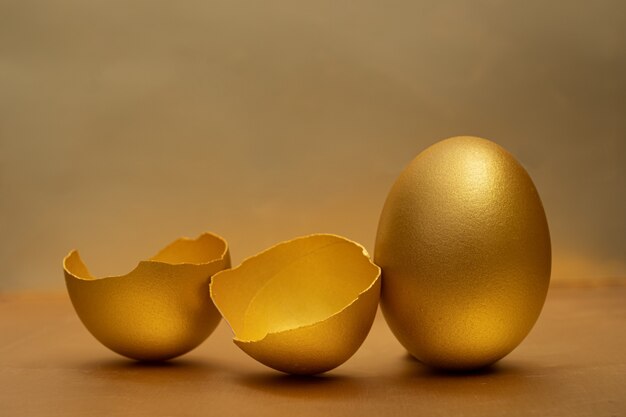 Golden egg and half broken eggs