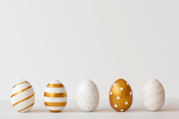 Золотые яйца на белом фоне Минимальная пасхальная концепция