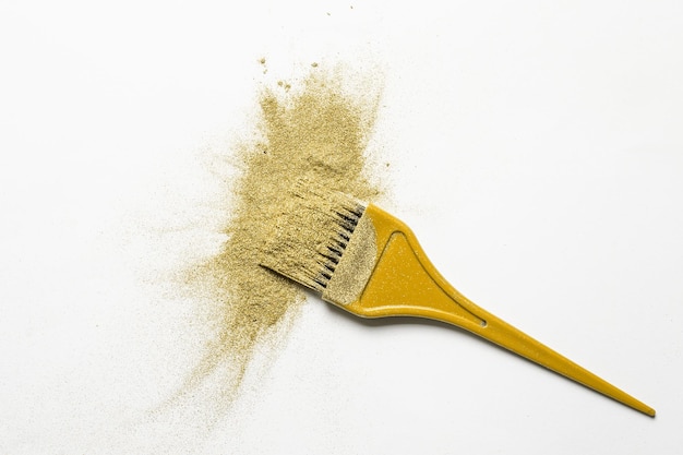 Golden fine powder splash and brush for makeup artist or graphic design in white background