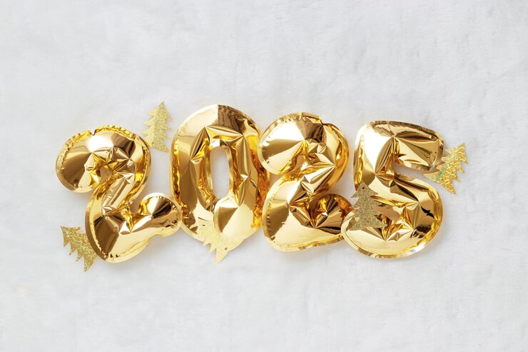 Golden foil balloons forming number 2025 and sparkly gold trees on white fur background Happy New Year Eve celebration concept top view flat lay Festive Christmas decorations for winter holiday