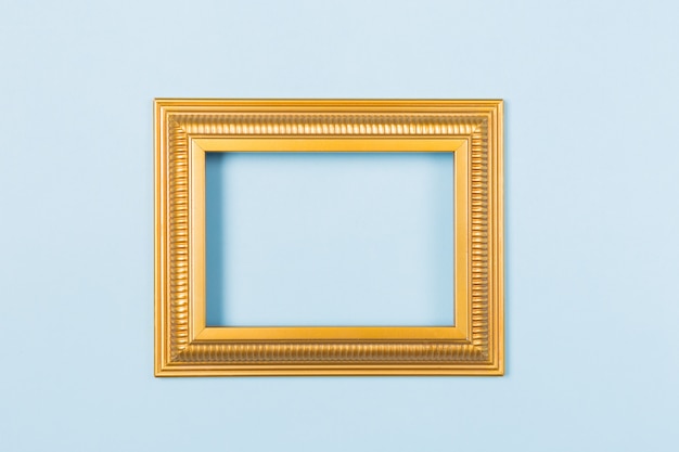 Golden frame empty blank picture on light blue background .