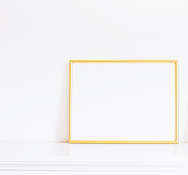 Photo golden frame on white furniture luxury home decor and design for mockup poster print and printable a...