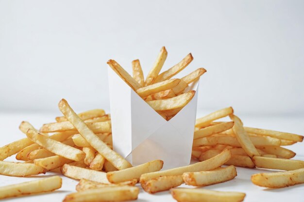 Photo golden french fries in a white carton