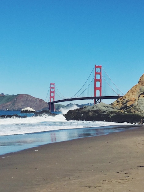 Golden gate bridge over sea against clear blue sky