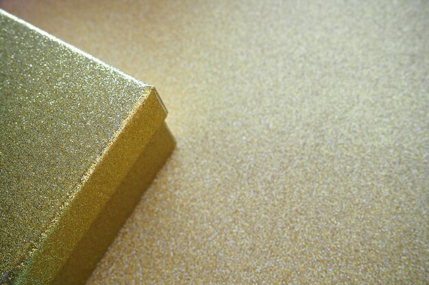 Golden gift box on a golden background Decorative surprise box Copy space