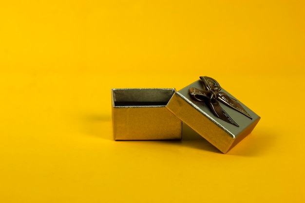 사진 황금색 선물 상자는 노란색 배경에 열리고 텍스트 설명 개념 디자인을위한 간격을 제공합니다.