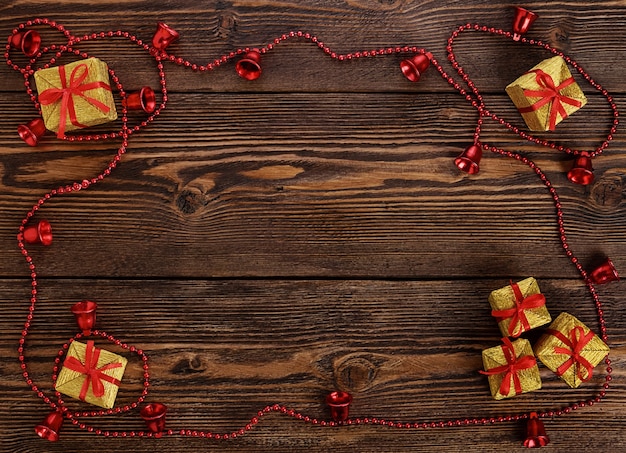 Golden gift boxes and bells around on wooden table.