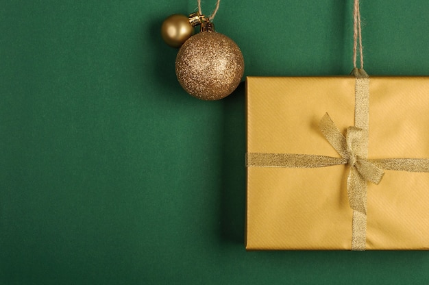 golden gift with christmas decorations on green background