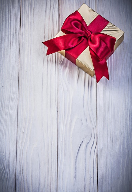 Golden giftbox with present on wood board holidays concept