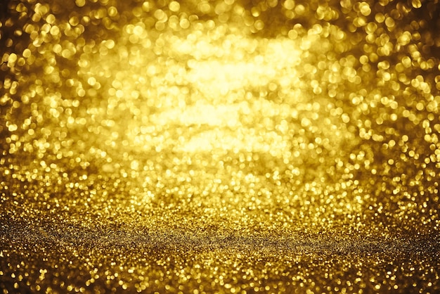 金色のキラキラボケ照明テクスチャ誕生日記念日の結婚大晦日またはクリスマスのぼやけた抽象的な背景