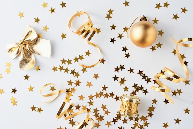 Golden glitter confetti and decorations on a white surface