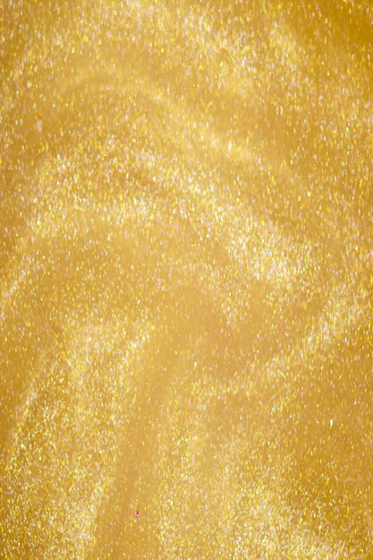 Golden glitter dust on dark background.