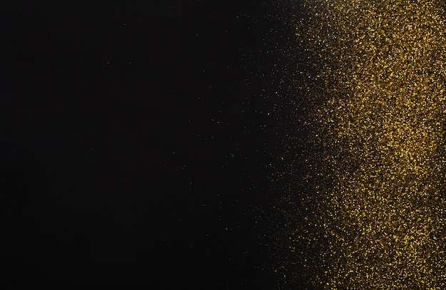 Golden glitter sand isolated on black