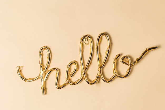 Photo golden hello sign on a bright surface