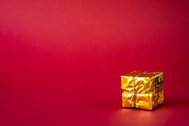 Golden holiday gift box on red