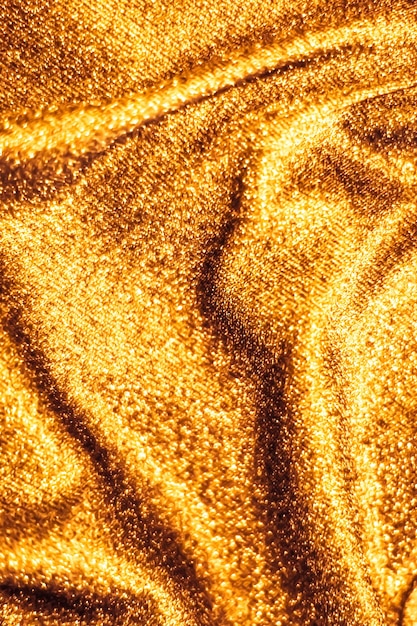 Golden holiday sparkling glitter abstract background luxury shiny fabric material for glamour design and festive invitation