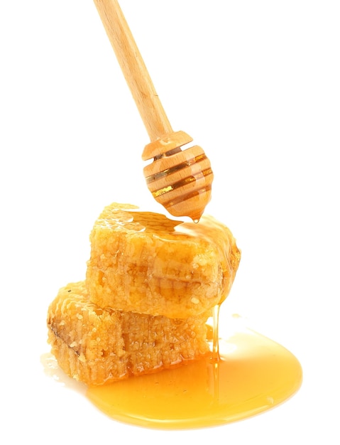 Golden honeycombs and wooden drizzler with honey isolated on white