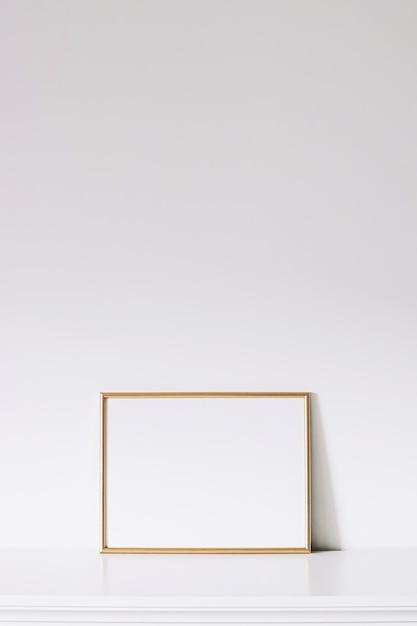 Foto cornice orizzontale dorata su mobili bianchi