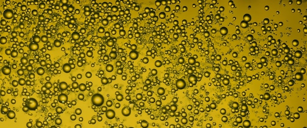 Golden hyaluron oil bubbles collagen serum or yellow oil bubbles drop texture background liquid transparent droplets skincare essential product with dribs honey syrup bubble oil droplets close up