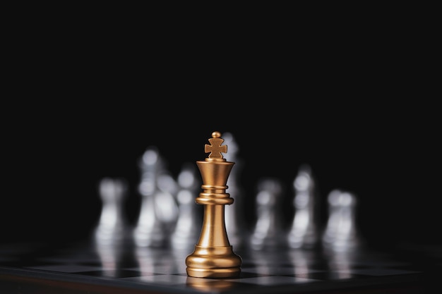 Golden king chess in front of silver pawn chess on chess board and black background.