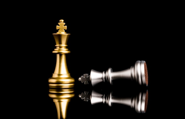 Golden king chess standing and silver king chess falling for the winner , business competitor and strategy concept.