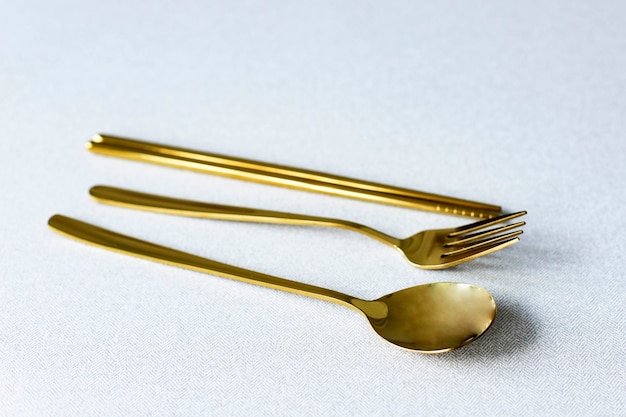 Golden Korean Sujeo Set, Traditional Korean Flatware with Spoon Fork and Chopstick. Isolated on Grey Background