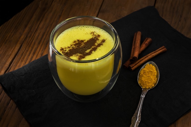 写真 シナモンと黄金のラテ。伝統的なインドの飲み物ターメリックミルク