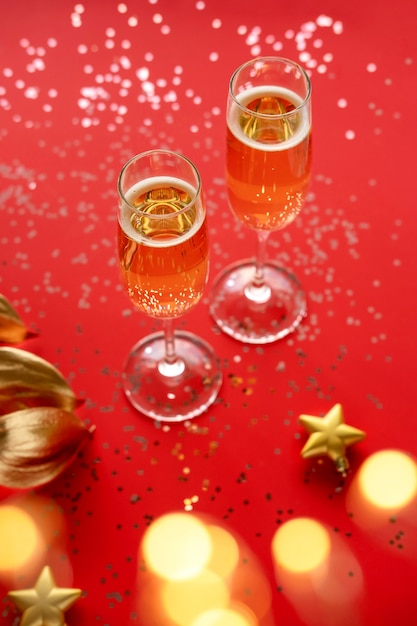 Golden leaf and glasses of champagne isolated on red