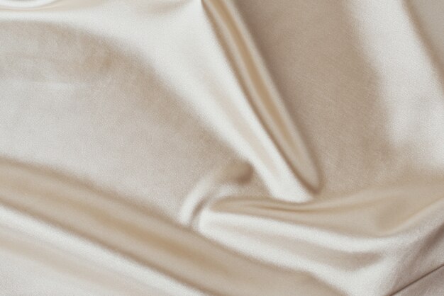 Golden light silk with folds.  Abstract texture of rippled satin surface