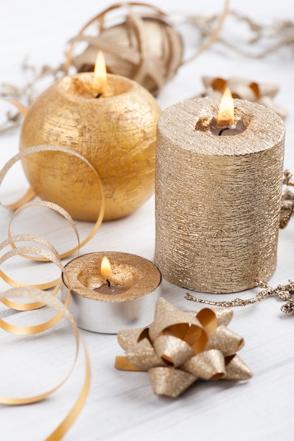 Golden lit aroma candles and Christmas toys on wooden rustic background