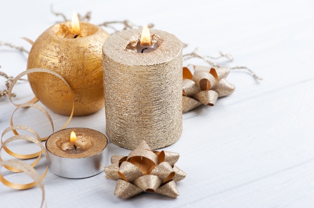 Golden lit aroma candles and Christmas toys on wooden rustic